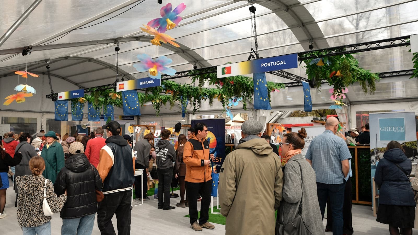 Visitors browsing branded stalls inside a busy on-ground activation marquee